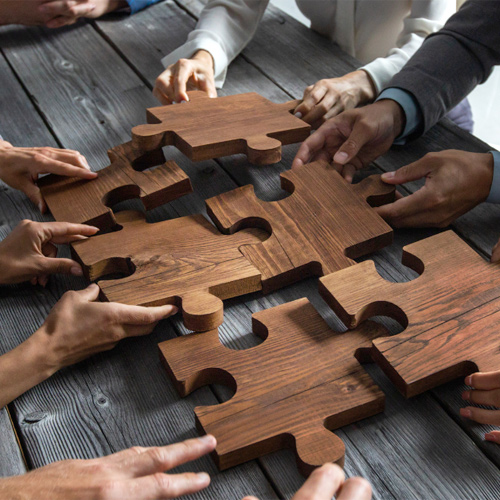 a bunch of people putting big pieces of puzzle together